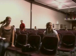 Zwei Mädchen sitzen in einem fast leeren Gemeinderaum und bemerken, dass die anderen Gemeindemitglieder entrückt wurden, denn die Entrückung hat gerade stattgefunden. Im Hintergrund sehen sich andere Gemeindemitglieder verwundert um.